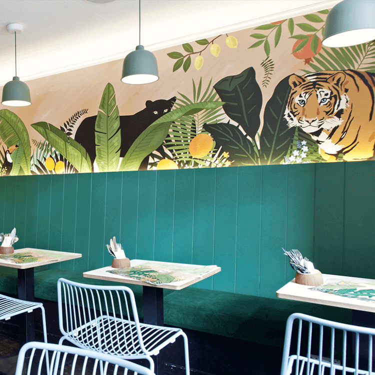 Jungle themed restaurant interior with green reupholstered banquette seating