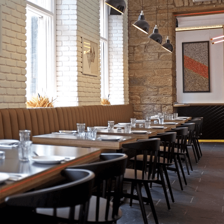 A contemporary restaurant interior with bespoke reupholstered banquette seating